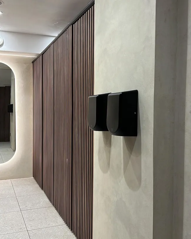 Siyah duvar rafı yanında açık tonlu microcement banyo duvarı