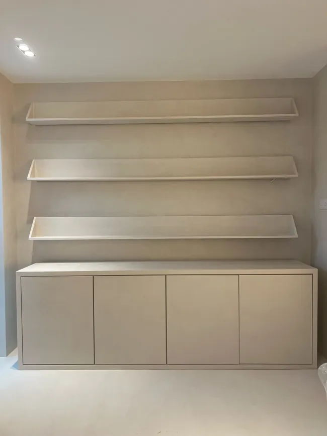 Gömme rafların bulunduğu açık tonlu microcement banyo duvarı