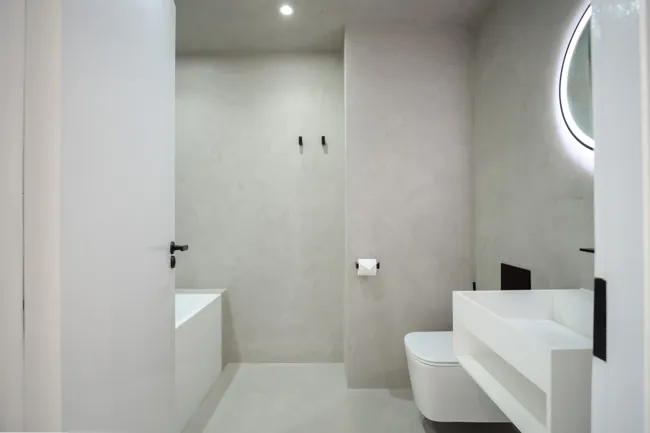 Duş ve lavabo alanında gri microcement duvar ve zemin yüzeyleri