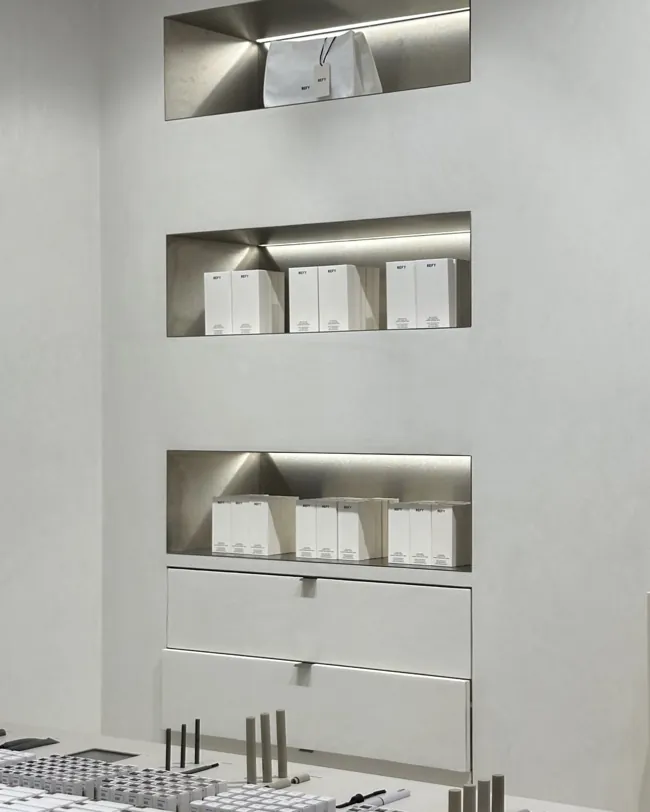 Lavabo üzerindeki raf nişleri çevresinde açık tonlu microcement duvar